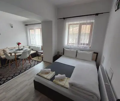 a bedroom with a large bed and a dining room at Къща за гости Иглика in Trigrad