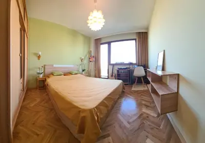 a bedroom with a bed and a desk and a window at Panoramic and Spacious Flat near the City Centre in Sofia