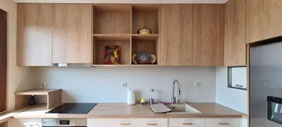a kitchen with wooden cabinets and a sink at Panoramic and Spacious Flat near the City Centre in Sofia
