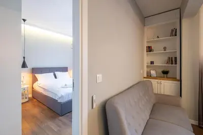 a bedroom with a bed and a chair in a room at Designer & Cozy 2BD Flat with a parking in the city center by Flat Mаnager in Sofia