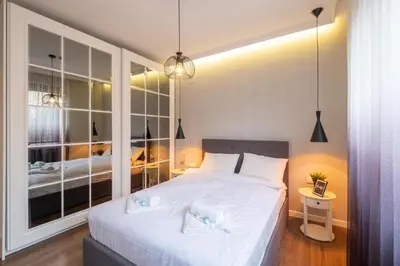 a bedroom with a white bed with a large window at Designer & Cozy 2BD Flat with a parking in the city center by Flat Mаnager in Sofia