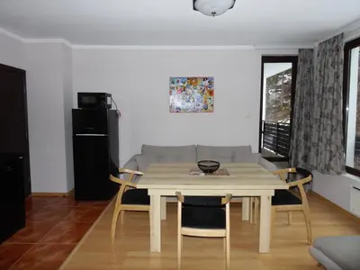 a living room with a table and a couch at Deer's Home at Elit Pamporovo in Pamporovo