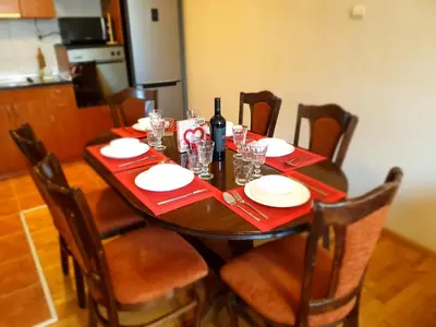 a wooden table with red napkins and a bottle of wine at Jasmine appart Metro station, 2BDR, FREE Parking in Sofia