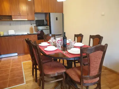 a dining room table with chairs and a bottle of wine at Jasmine appart Metro station, 2BDR, FREE Parking in Sofia