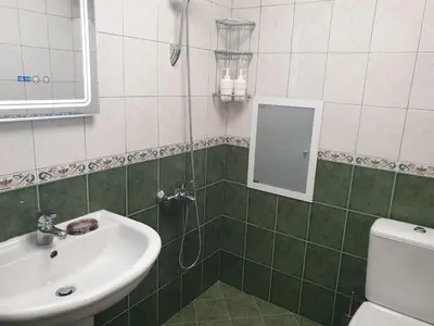 a green and white bathroom with a sink and a shower at Jasmine appart Metro station, 2BDR, FREE Parking in Sofia