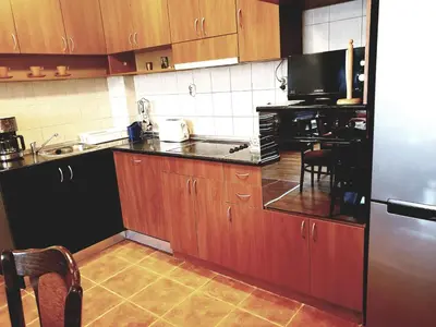 a kitchen with wooden cabinets and a stainless steel refrigerator at Jasmine appart Metro station, 2BDR, FREE Parking in Sofia