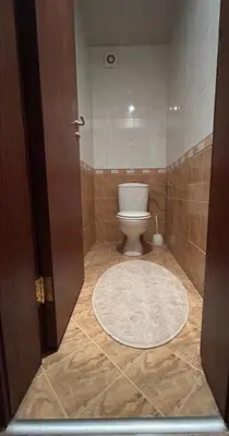 a bathroom with a toilet and a rug on the floor at Lovely 2-bedroom serviced apartment with SPA in Bansko