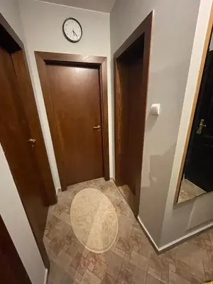 a hallway with a door and a clock on the wall at Lovely 2-bedroom serviced apartment with SPA in Bansko