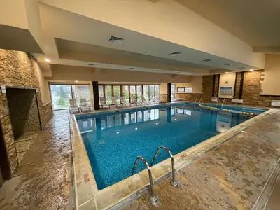 a large indoor swimming pool in a building at Lovely 2-bedroom serviced apartment with SPA in Bansko