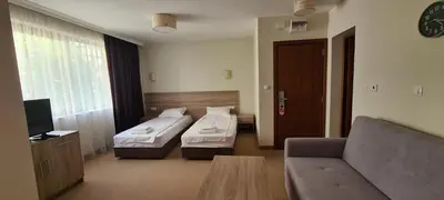 a hotel room with two beds and a couch at Hotel Geppy in Sofia