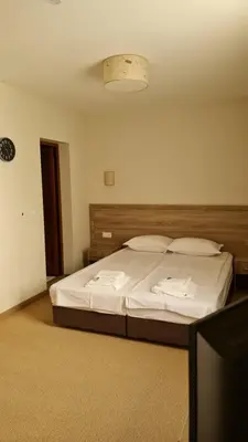 a bedroom with a bed with white sheets and pillows at Hotel Geppy in Sofia