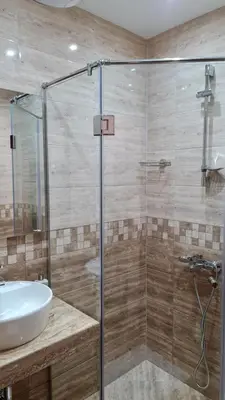 a bathroom with a glass shower and a sink at Hotel Geppy in Sofia