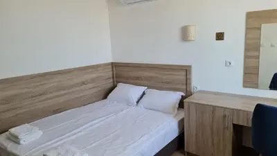 a small bedroom with a bed and a desk at Hotel Geppy in Sofia