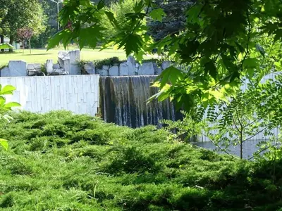a waterfall in a garden with green plants at Hotel Astra in Sandanski