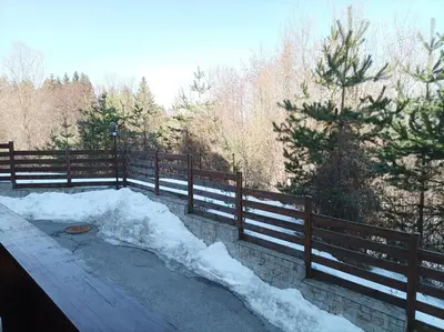 a pile of snow on the ground next to a fence at Apartment Detelina Residence in Bansko
