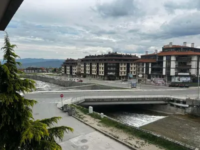 a bridge over a river in a city with buildings at Илен 433 Bansko Royal Towers in Bansko