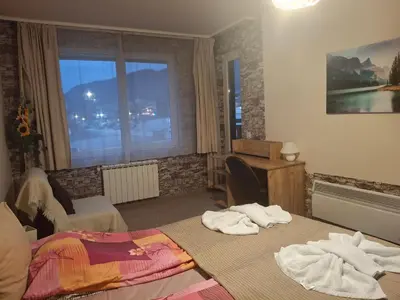 a bedroom with two beds and a desk and a window at Илен 433 Bansko Royal Towers in Bansko