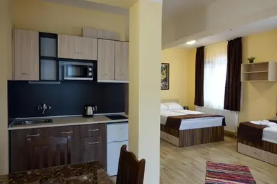 a hotel room with a kitchen and a bed at Борник Хил / Bornik Hill in Devin