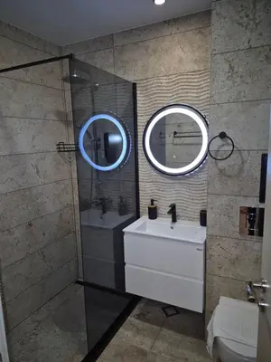 a bathroom with a sink and a shower with a mirror at Monteverde Ski Lift Apartment Bansko in Bansko