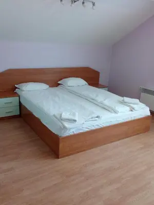a bedroom with a large bed with white sheets at Todorini Kuli Apartments in Bansko
