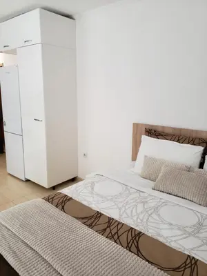 a white bedroom with a bed and a dresser at Ski-in ski-out Studio 2A7 Grand Monastery in Pamporovo