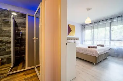 a bedroom with a bed and a glass shower at Sunny Apartment in Studentski grad, behind UNSS in Sofia