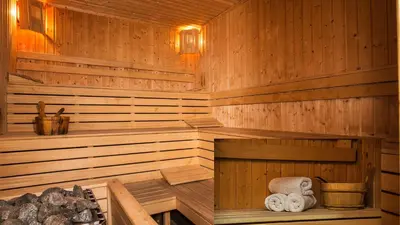a wooden sauna with towels sitting in it at Studio by Mountain Lakes in Ezerovo