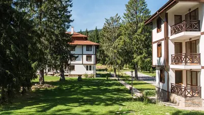 an apartment building with a yard with trees at Studio by Mountain Lakes in Ezerovo
