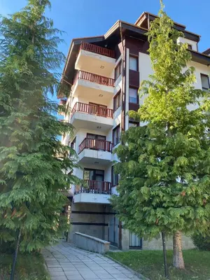 a tall building with trees in front of it at Apart Hotel Flora Residence - Clover Building Flat 09 in Borovets