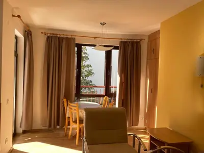 a living room with a table and a chair at Apart Hotel Flora Residence - Clover Building Flat 09 in Borovets
