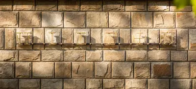 a brick wall with the shadows of chairs on it at HIDDEN BANK: Golden in Plovdiv