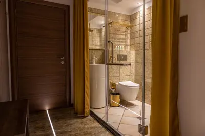 a bathroom with a toilet and a glass door at HIDDEN BANK: Golden in Plovdiv