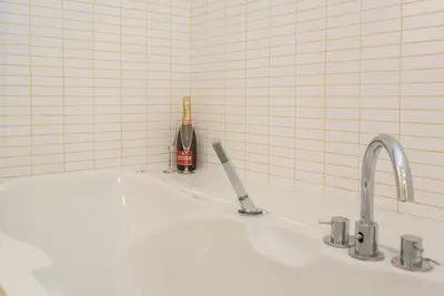 a white sink with a bottle of wine and a bottle of champagne at Modern Apartment in the City Center in Sofia