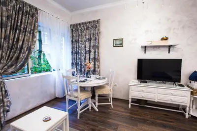 a living room with a table and a television at TOP CENTER Designer studio 1 minute to NDK&Vitosha by Flat Mаnager in Sofia