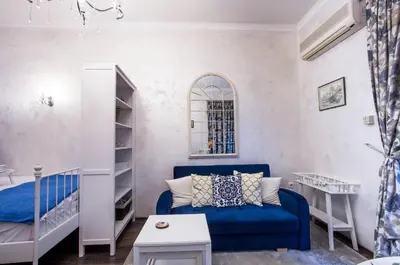 a living room with a blue couch and a bed at TOP CENTER Designer studio 1 minute to NDK&Vitosha by Flat Mаnager in Sofia