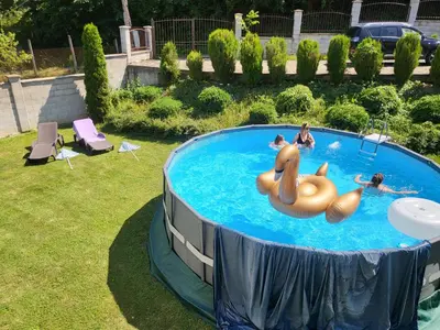 a group of people swimming in a pool at Двете къщи в планината in Beli Osŭm