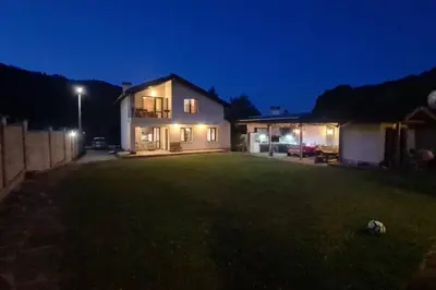 a large yard with a house at night at Двете къщи в планината in Beli Osŭm