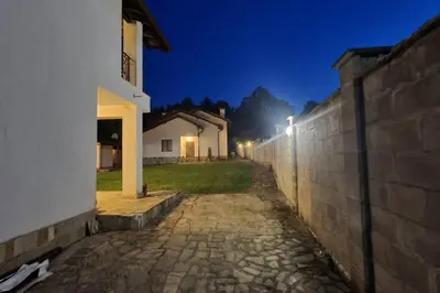 a stone pathway next to a wall at night at Двете къщи в планината in Beli Osŭm