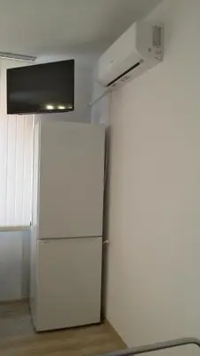 a white refrigerator in a room with a microwave at Парк Апартаменти Юлия in Sandanski