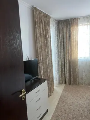 a room with a door and a tv on a dresser at Гранд Манастира Пампорово in Pamporovo