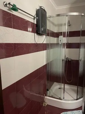 a shower in a bathroom with red and white tiles at Гранд Манастира Пампорово in Pamporovo