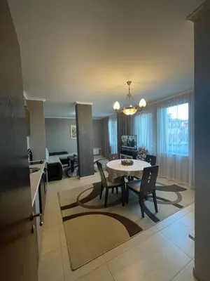 a dining room and living room with a table and chairs at Гранд Манастира Пампорово in Pamporovo