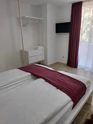 a bedroom with a large bed with a red blanket at Stella Guesthouse in Sapareva Banya