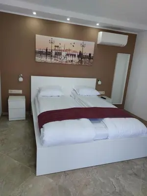 a bedroom with a large white bed in it at Stella Guesthouse in Sapareva Banya