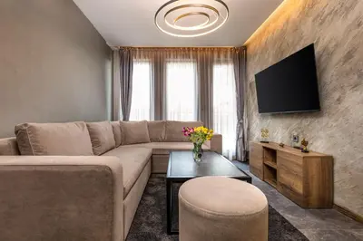 a living room with a couch and a tv at SOHO Apart House in Plovdiv