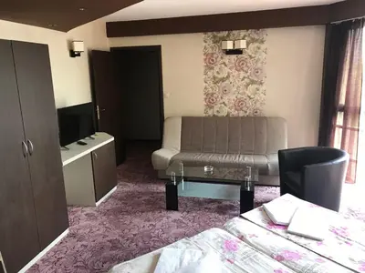 a hotel room with a couch and a tv at Casa Blanca in Sofia