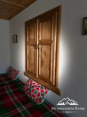a wooden cabinet in a corner of a bedroom at Музикалната къща in Breze