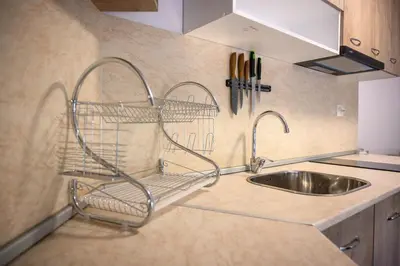 a kitchen sink with a metal rack next to a sink at Апартаменти ЗДРАВЕ in Sapareva Banya