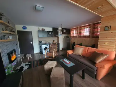 a living room with a couch and a table at Family apartment VYANI in Bansko