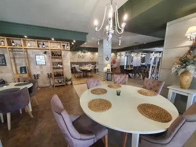 a dining room with a white table and chairs at Family apartment VYANI in Bansko
